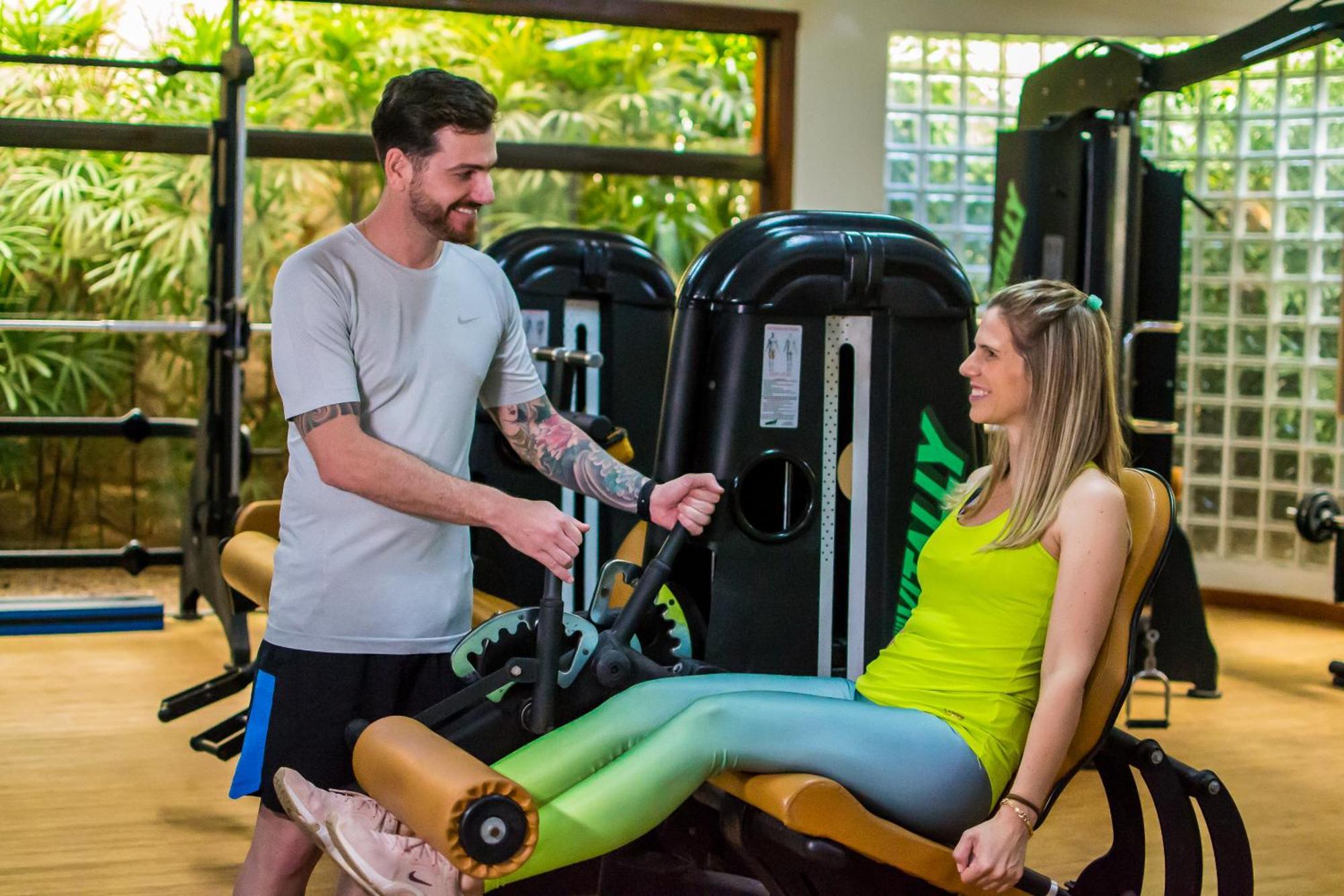 Blue Tree Thermas De Lins Resort Exterior foto Personal trainer assisting a woman on a leg press machine